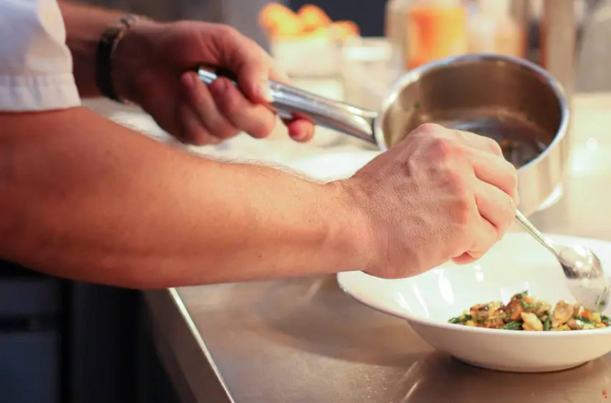 Chef plating food in a modern kitchen with focus and precision